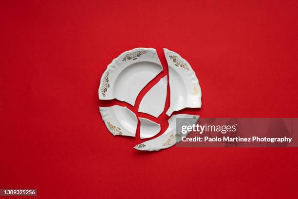 broken white plate on red background - shattered glass stock pictures, royalty-free photos & images
