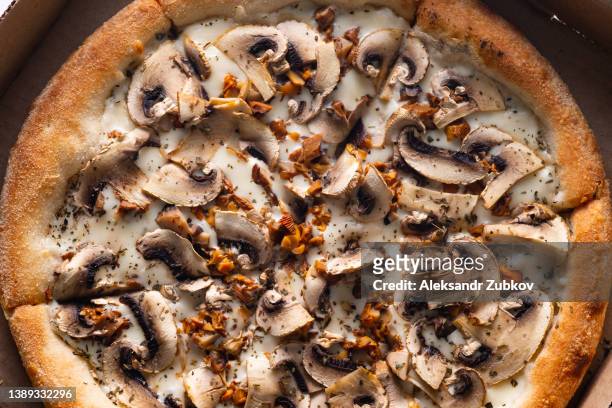 slices of italian vegetable pizza with cheese and mushrooms and champignons, in a cardboard box or packaging for delivery, on a wooden kitchen table, at home, in a cafe or pizzeria. the concept of vegetarian food, home delivery. fast food. - vegetable pizza stock pictures, royalty-free photos & images