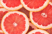Food background - Texture of a ripe grapefruit slices, closeup. Grapefruit background.