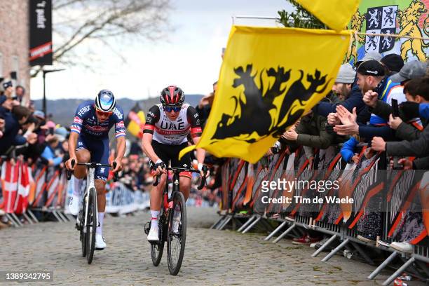 Mathieu Van Der Poel of Netherlands and Team Alpecin-Fenix and Tadej Pogacar of Slovenia and UAE Team Emirates while fans cheer during the 106th...