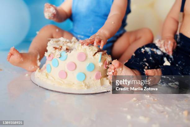 birthday cake close-up is broken by kids, funny children's party - eerste verjaardag stockfoto's en -beelden