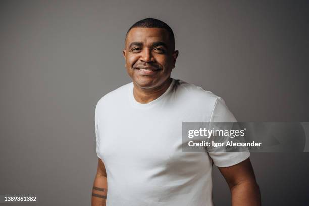 porträt eines mannes mit weißem t-shirt im studio - african american man wearing shirt stock-fotos und bilder