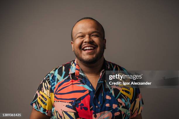 smiling man wearing colorful outfit in studio - plus size model stockfoto's en -beelden