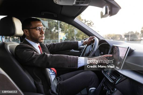 businessman putting direction of his work in gps of car - business person driving stockfoto's en -beelden