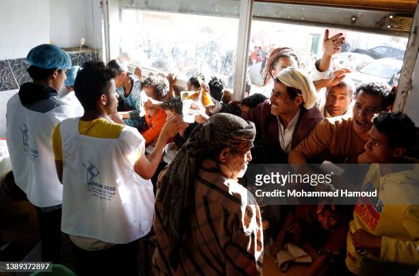 People affected by war receive free meals provided by a charitable kitchen in the Mseek area on April 03, 2022 in Sana'a, Yemen. A two-month...
