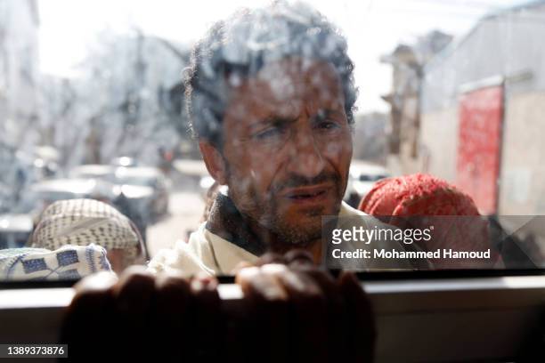 Man affected by war waits to receive free meals provided by a charitable kitchen in the Mseek area on April 03, 2022 in Sana'a, Yemen. A two-month...