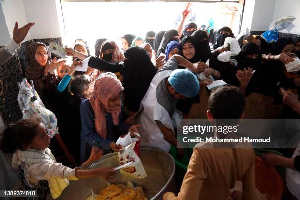 People affected by war receive free meals provided by a charitable kitchen in the Mseek area on April 03, 2022 in Sana'a, Yemen. A two-month...