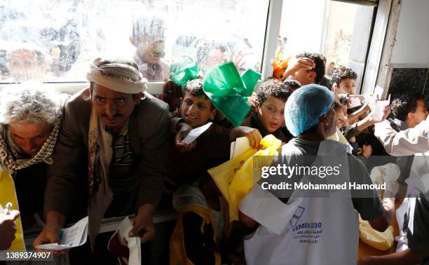 People affected by war receive free meals provided by a charitable kitchen in the Mseek area on April 03, 2022 in Sana'a, Yemen. A two-month...