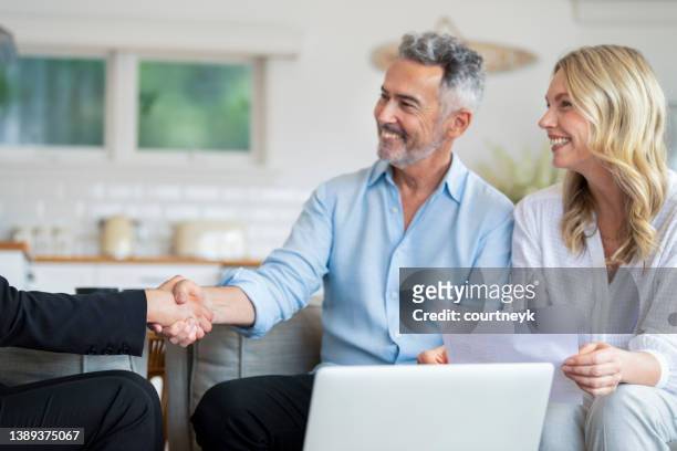 happy mature couple meeting investments and financial advisor at home - inheritance consulting stockfoto's en -beelden