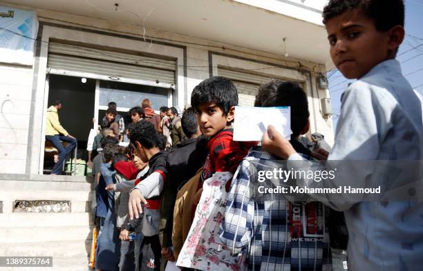 Children affected by war line up to receive free meals provided by a charitable kitchen in the Mseek area on April 03, 2022 in Sana'a, Yemen. A...