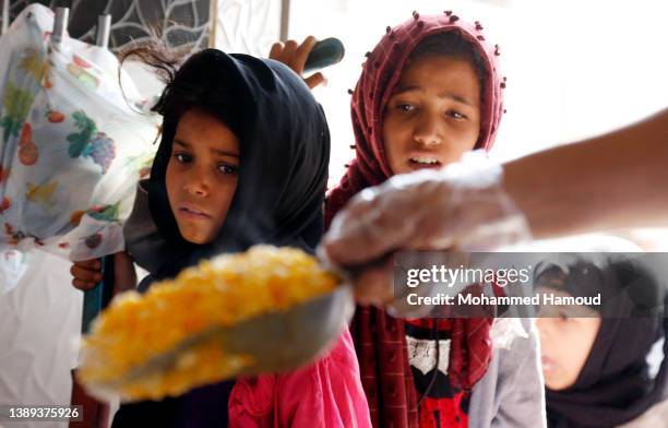 Girls affected by war wait to receive free meals provided by a charitable kitchen in the Mseek area on April 03, 2022 in Sana'a, Yemen. A two-month...