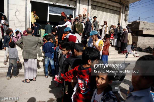 Children affected by war line up to receive free meals provided by a charitable kitchen in the Mseek area on April 03, 2022 in Sana'a, Yemen. A...