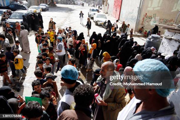 People affected by war receive free meals provided by a charitable kitchen in the Mseek area on April 03, 2022 in Sana'a, Yemen. A two-month...