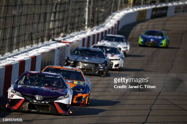Denny Hamlin, driver of the FedEx Express Toyota, leads a pack of cars during the NASCAR Cup Series Toyota Owners 400 at Richmond Raceway on April...