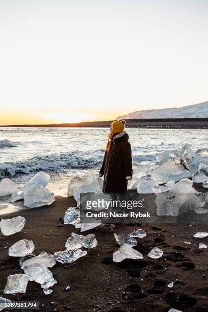 a mulher curte o pôr do sol em diamond beach, na islândia - laguna jokulsarlon - fotografias e filmes do acervo