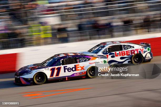Denny Hamlin, driver of the FedEx Express Toyota, and William Byron, driver of the Liberty University Chevrolet, race during the NASCAR Cup Series...