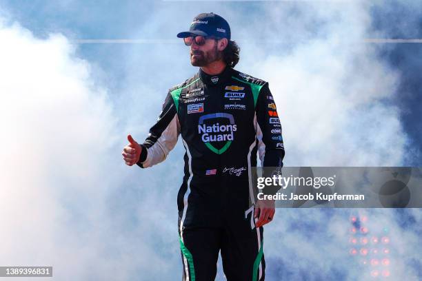 Corey LaJoie, driver of the Nations Guard Chevrolet, waves to fans onstage during driver intros prior to the NASCAR Cup Series Toyota Owners 400 at...