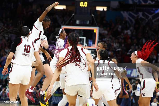 Kamilla Cardoso, Zia Cooke, and Victaria Saxton of the South Carolina Gamecocks celebrate with teammates after defeating the UConn Huskies 64-49...