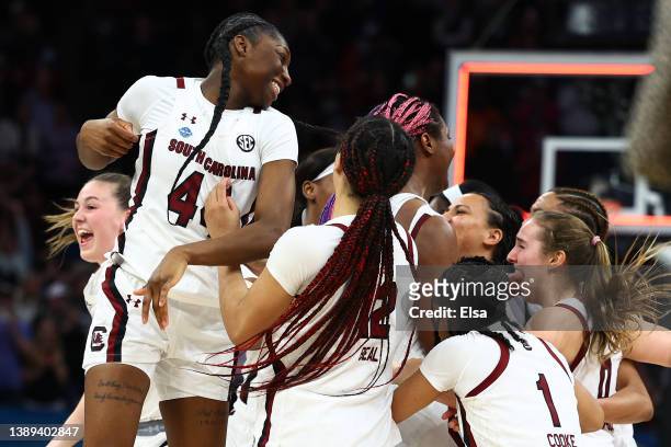Saniya Rivers and Brea Beal of the South Carolina Gamecocks celebrate with teammates after defeating the UConn Huskies 64-49 during the 2022 NCAA...