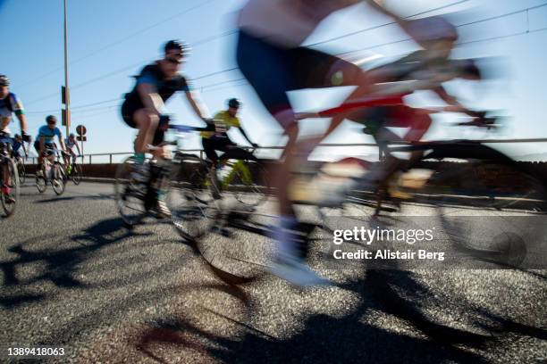 cyclists racing together at dawn in a large scale cycle event - ロードバイク ストックフォトと画像