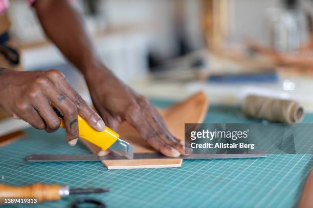 close up of female small business owner working in her leatherwork studio - leather craft stock pictures, royalty-free photos & images