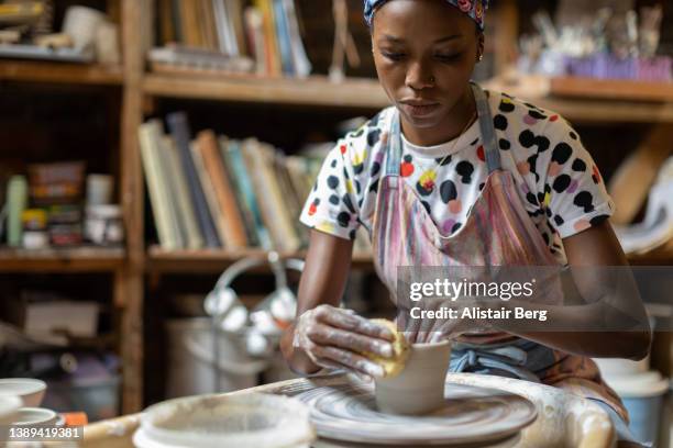 female potter creating a bowl in her art studio - pottery making stock pictures, royalty-free photos & images