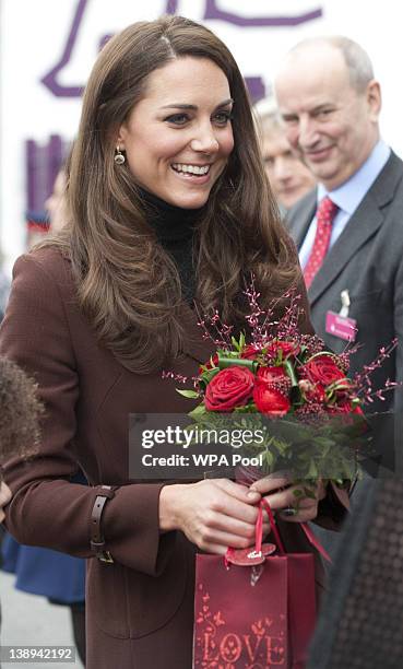 Catherine, Duchess of Cambridge holds a posey of red roses presented to her by Eight-year-old Jaqson Johnston-Lynch after her visit to charity The...