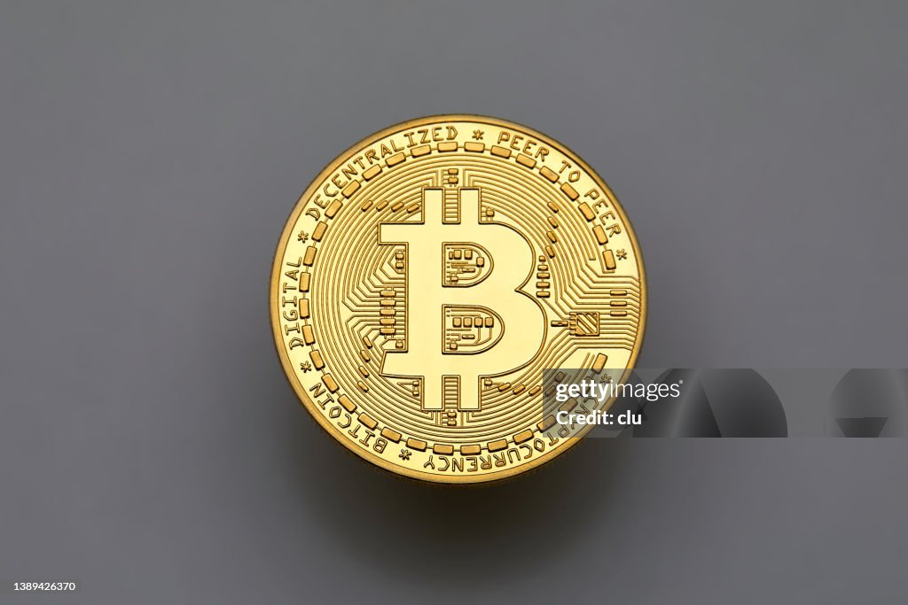 Einzelne Bitcoin auf grauem Hintergrund, von oben