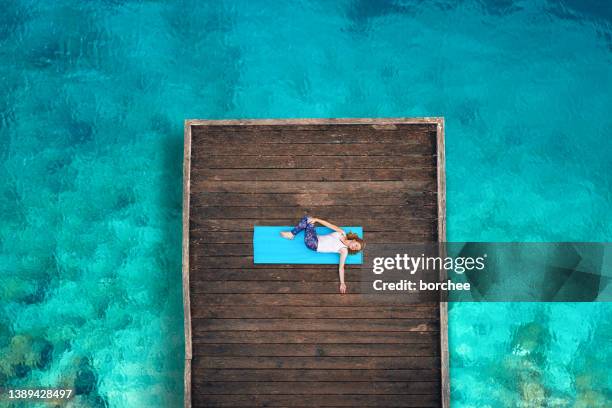 woman doing yoga by the sea - slovenia beach stock pictures, royalty-free photos & images