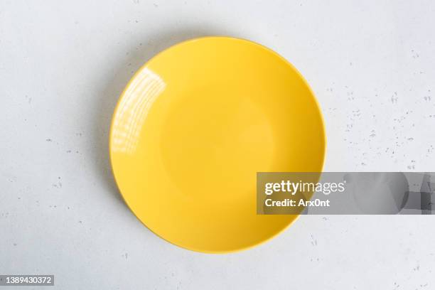 empty yellow plate on grey concrete table background - plate stock pictures, royalty-free photos & images