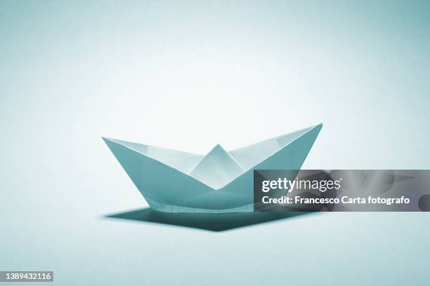 light blue paper boat - paper boat stock-fotos und bilder