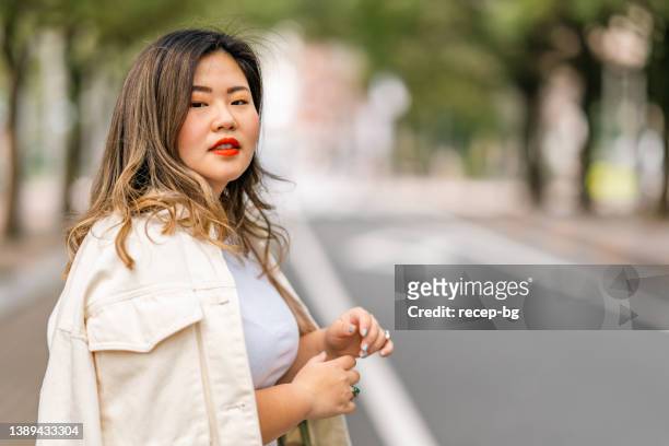 portrait of beautiful body positive woman in city - plus size model fitness stock pictures, royalty-free photos & images