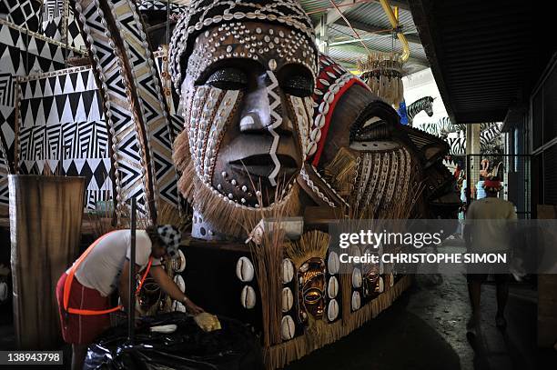 People give the finishing touches to a float of the "Vila Isabel" samba school, whose theme this year is "Angola", ahead of Rio de Janeiro's...
