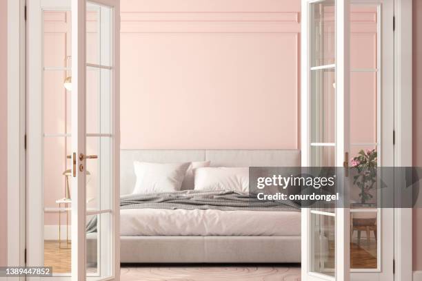 vista frontale dell'ingresso della camera da letto con porta aperta, letto e sfondo a parete rosa - legno rosa foto e immagini stock