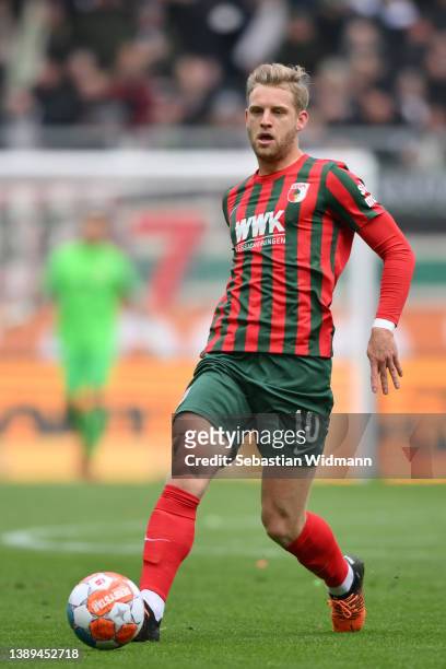 Arne Maier of FC Augsburg plays the ball during the Bundesliga match between FC Augsburg and VfL Wolfsburg at WWK-Arena on April 03, 2022 in...