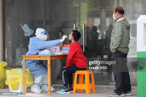 Medical worker collects swab sample from a child for COVID-19 nucleic acid test on April 4, 2022 in Shanghai, China. Shanghai launched citywide...