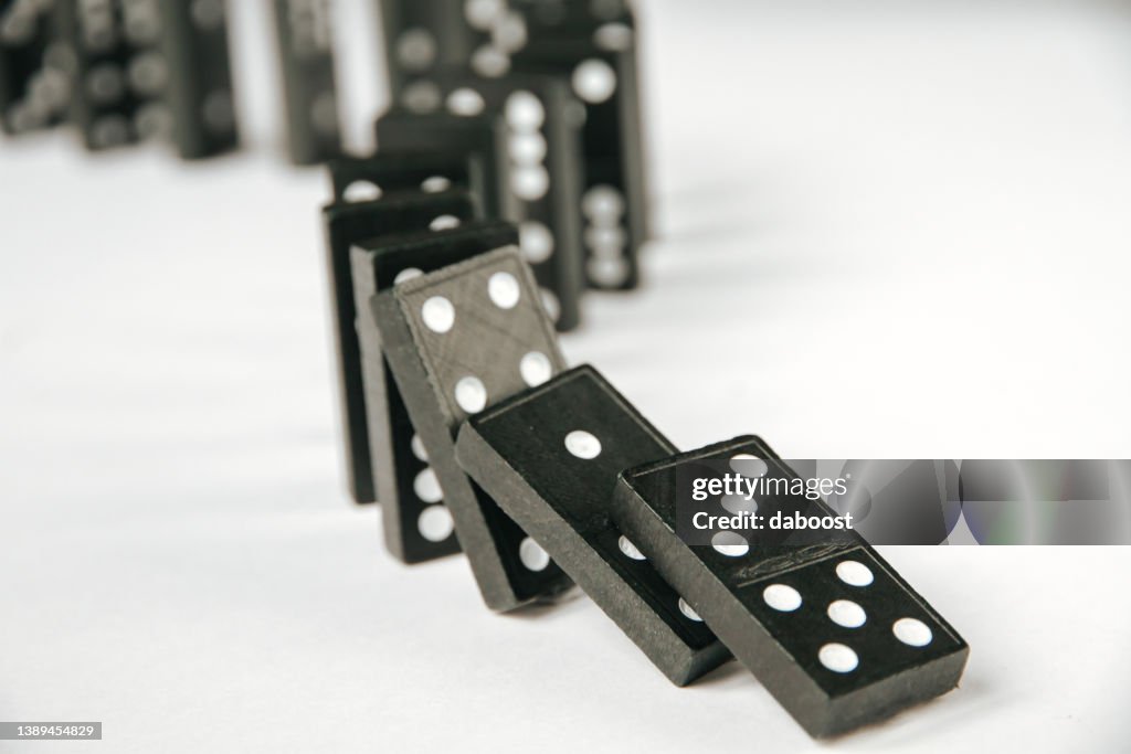 Black dominoes chain on white table background