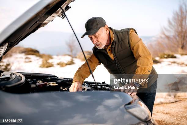 senior man with his broken car on the side of a country road - car inspection stock pictures, royalty-free photos & images