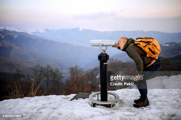 senior hiker using observation binoculars on the mountain - looking through an object stock pictures, royalty-free photos & images