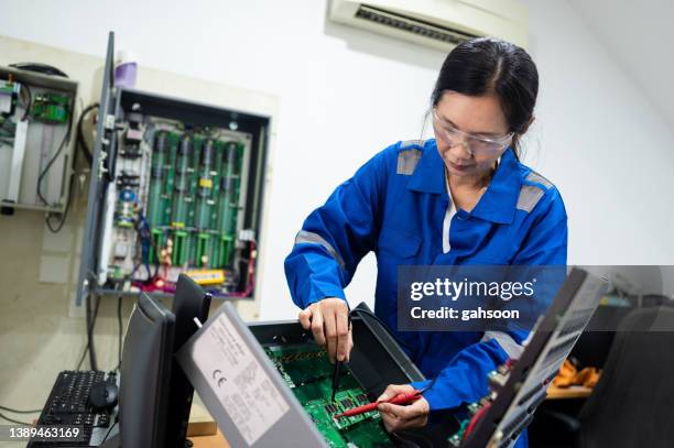 female electrician working on circuit board at desk - disassembling stock pictures, royalty-free photos & images