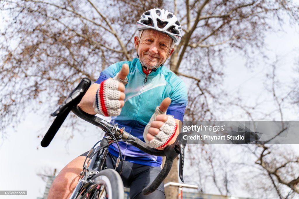 Senior man on road bike, looking at camera