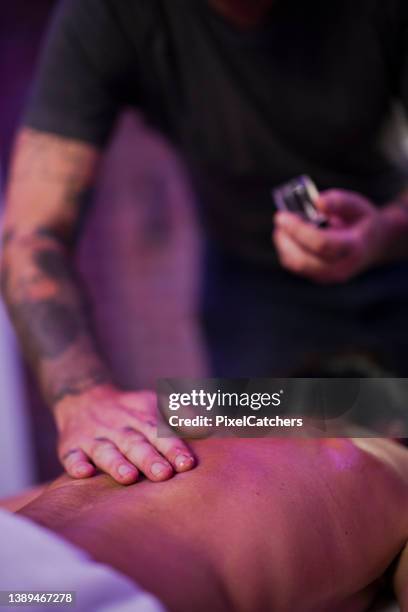 la mano di messa a fuoco selettiva strofina l'olio sulla schiena - arnica foto e immagini stock