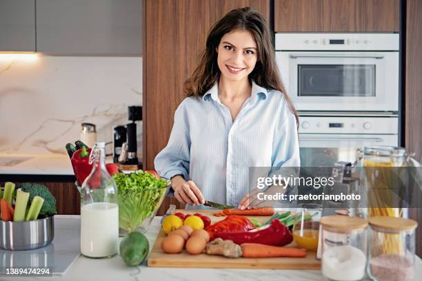 portrait of young woman cooking in a kitchen - funny vegetable stock pictures, royalty-free photos & images