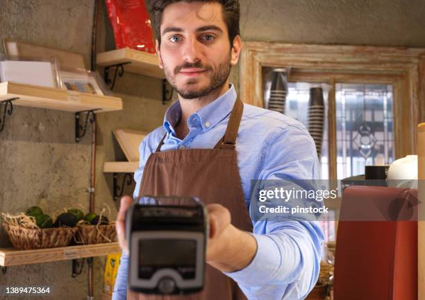 young cafe owner giving payment with credit card - pos machine stock pictures, royalty-free photos & images