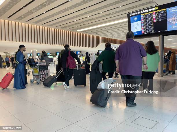 Passengers queue for check in at Manchester Airport's terminal 2 on April 04, 2022 in Manchester, United Kingdom. Covid checks, high passenger...