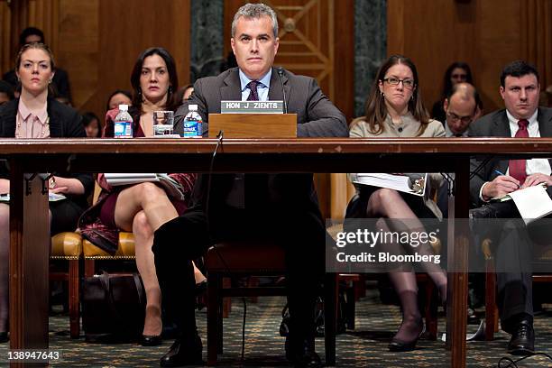 Jeffrey Zients, acting director of the Office of Management and Budget , center, and his staff listen to a question during a Senate Budget Committee...