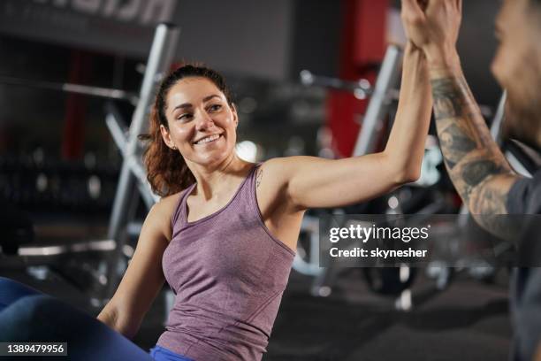 donna atletica felice che dà al suo amico il cinque durante una pausa in palestra. - hi five gym foto e immagini stock