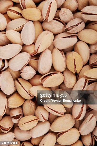 pistachio nuts as a background - cáscara de nuez fotografías e imágenes de stock