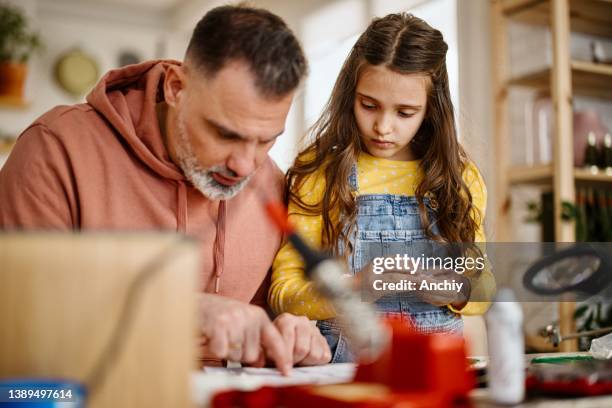 father and daughter building robot - school project stock pictures, royalty-free photos & images