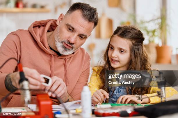 a father and daughter put a robot together for a school science project - school science project stock pictures, royalty-free photos & images